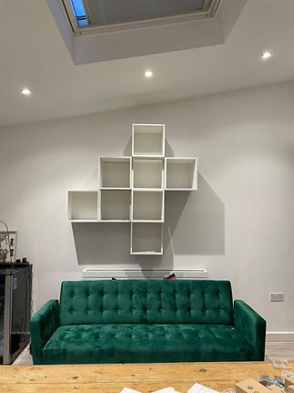 Emerald green velvet sofa in a modern minimalist living room with white walls