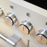 Close-up of stainless steel cooker control knobs on modern oven