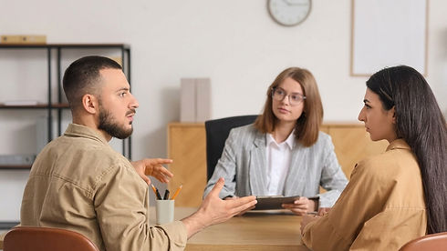 Professional interpreter facilitating conversation between man and woman across office desk