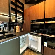 Modern kitchen corner with warm wood cabinets and appliances