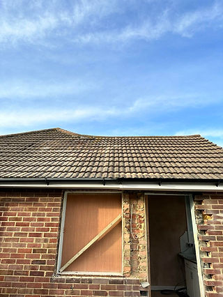 Existing tiled roof on a brick house requiring maintenance or replacement
