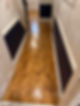 Bright hallway with glossy, herringbone pattern flooring