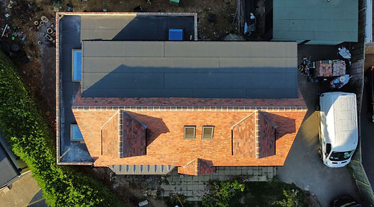 Aerial view of a residential roof with terracotta tiles.