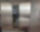 Tall slimline glass fronted wine refrigerator with wooden shelving