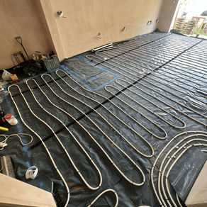 Overview of a complete underfloor heating system installation across a spacious open plan floor