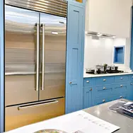 Tall integrated fridge freezer in stylish blue kitchen cabinetry