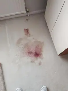 Pink and red stains on a light-coloured carpet
