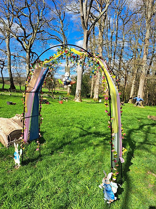 Blurred sunny landscape showing a tree trunk and green grass under a vibrant blue sky