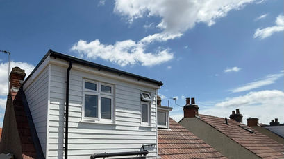 A finished white-clad dormer loft conversion with two windows on a red-tiled roof