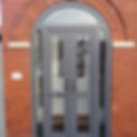 Grey arched uPVC double front doors set in a red brick wall