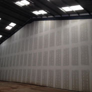 Long corridor featuring professional dry lining wall construction in a commercial unit