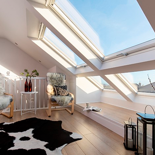 Large sloping roof windows in a bright loft conversion with modern seating