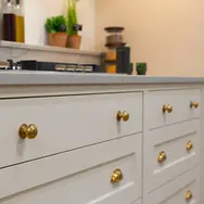 White shaker kitchen drawers with brass handles in fitted kitchen display
