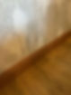 Detailed view of clean wooden skirting board meeting patterned wallpaper and flooring