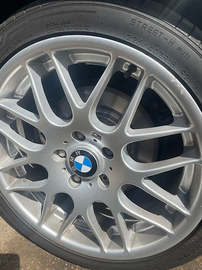 Close-up of a silver multi-spoke BMW alloy wheel with the centre cap and tyre sidewall showing the size