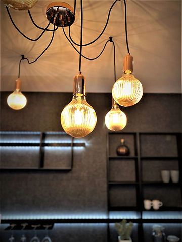Warmly lit hanging light bulbs with exposed filaments create a cozy ambiance against a dark
