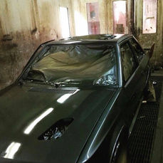 Car masked and prepared for respray in paint booth