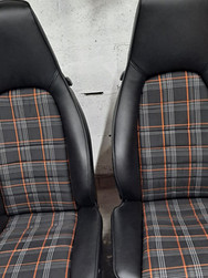 Pair of black car front seats with plaid fabric centres