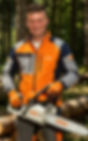 Smiling male arborist outdoors wearing an orange work jacket