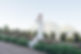 Bride in a lace wedding dress with long train standing on a stone path with mountain views