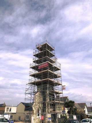 Tall narrow tower structure completely enclosed in metal scaffolding