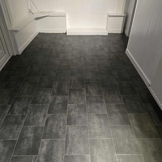 Industrial style dark grey tiled vinyl flooring in a clean utility area
