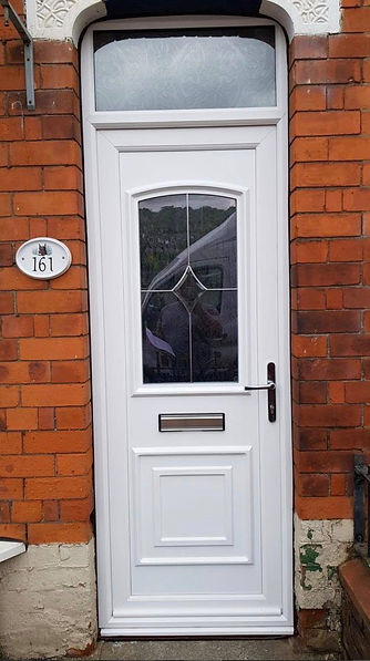 White uPVC front door with a decorative glass panel and letterbox set in a red brick wall