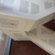 Close up of expert dry lining finishing on a complex ceiling and wall junction