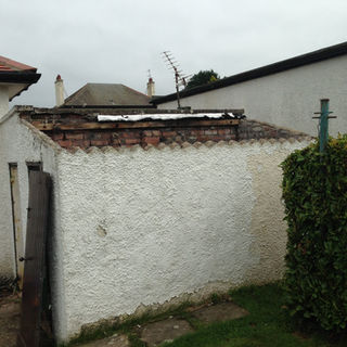 Interior view of a roofless brick structure showing weathered walls and an aerial on the neighbouring house