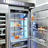 Open style fridge freezer stocked with food and drinks