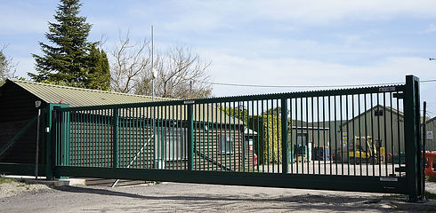 A large metal gate blocks the view of a compound
