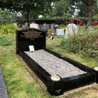 Black polished granite kerb set memorial with gold lettering and decorative grey chippings