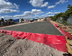 Concrete slab foundation with red edge formwork on commercial site