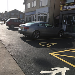 A silver car parked on a newly constructed parking area with fresh asphalt