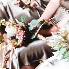 Detailed shot of a bridesmaid holding a white rose bouquet