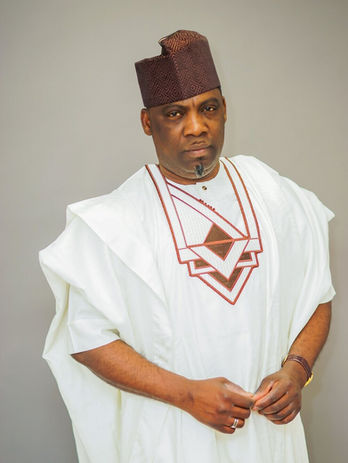 A man wearing a white and brown traditional outfit and a brown cap