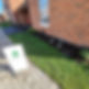 Freshly laid lawn in front of a brick house with a sign