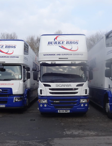 White and blue Burke Bros Global Relocation Scania moving trucks parked for nationwide and European coverage