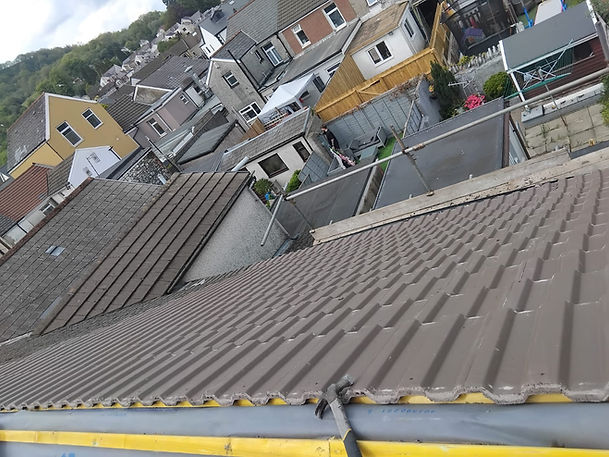 High-angle close-up view of grey concrete roof tiles and gutter edge on residential house