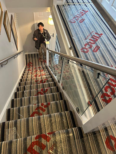 Person descending carpeted stairs with striped pattern