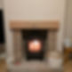 Traditional black log burner installed in a red brick fireplace with a solid oak mantle