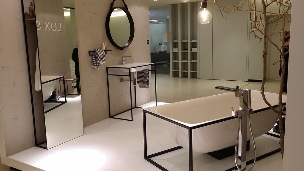 Contemporary bathroom with a white tub and basin, both set in stark black geometric metal frames