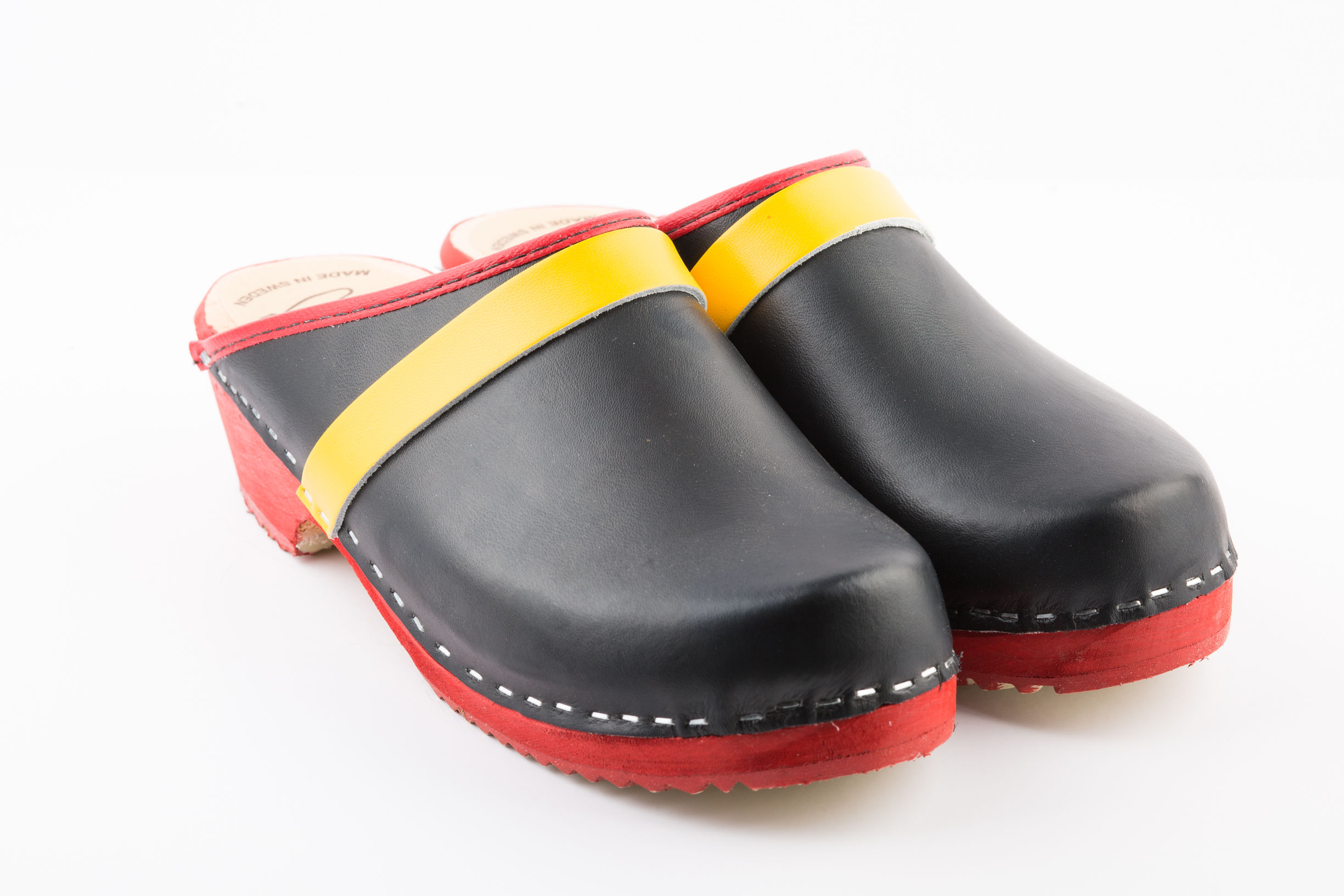 Black colored clogs with yellow stripe