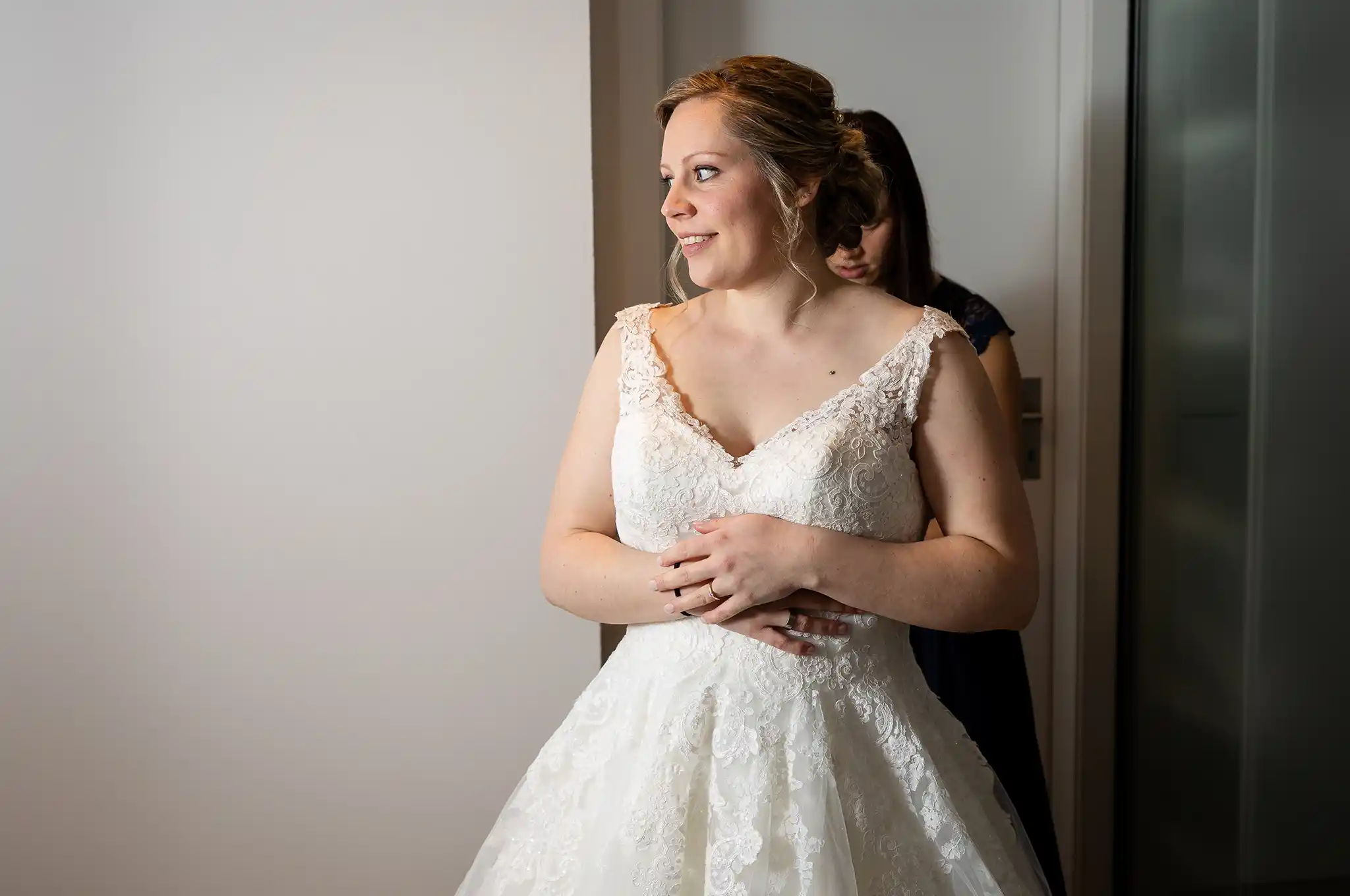 Braut im Brautkleid im Zimmer mit Trauzeugin