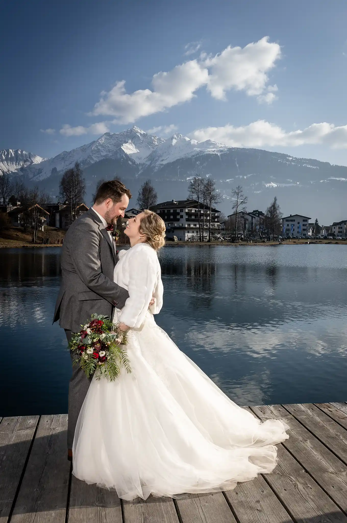 Brautpaar steht auf dem Steg am Laaxer See und schaut sich an