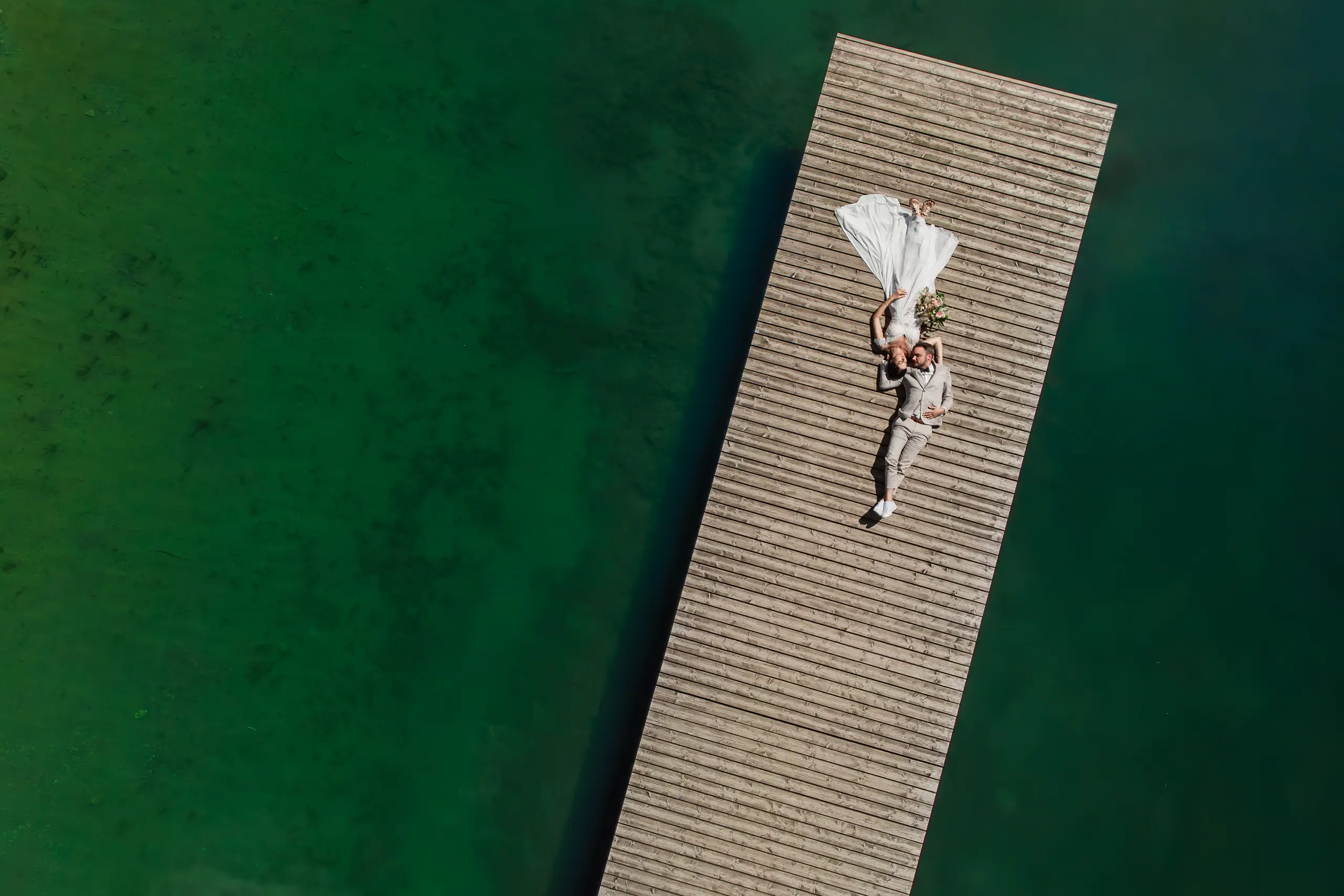 Hochzeitspaar am Bergsee aus der Vogelperspektive
