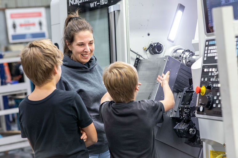 Employée de JLM devant une machine avec ses enfants