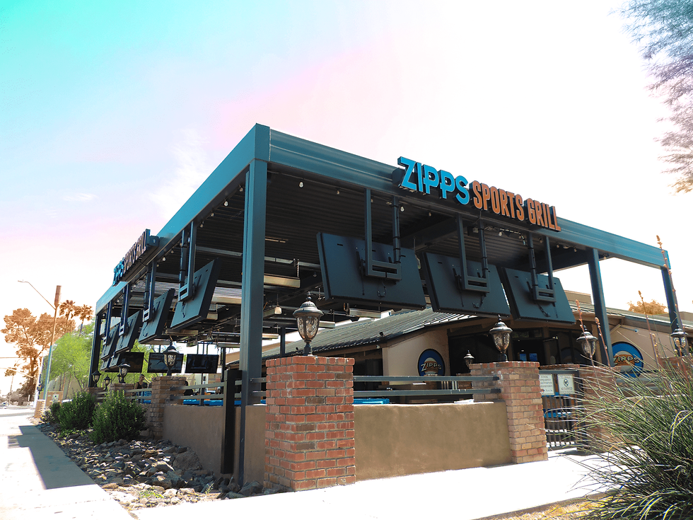 Exterior of Zipps Sports Grill with blue signage, brick accents, and an open patio under a bright sky