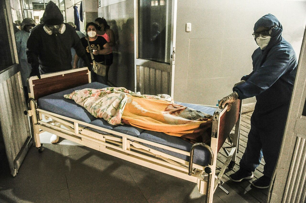 Cuerpo de víctima de la pandemia es llevado por integrantes del equipo humanitario que armarán el féretro. Créditos: Hildebrandt en sus trece/ Hugo Alejos.