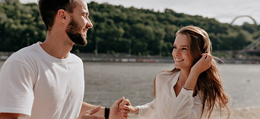 happy-young-couple-love-smiling-while-covering-beach-near-lake.jpg